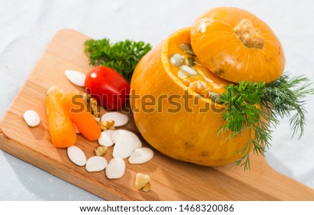 Dietary squash soup in baked pumpkin bowl. Recipe: flesh of whole baked pumpkin pull out with spoon, puree in blender, add olive oil, salt, pepper. Pour in pumpkin. Serve with greens and pumpkin seeds