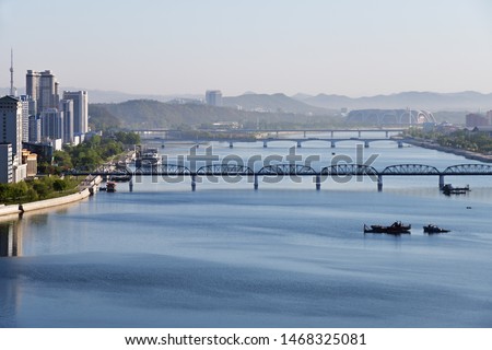Pyongyang, DPR Korea North Korea and Taedong River in the sunrise. View facing upstream, modern residential complex, Taedong bridge from the Yanggakdo island Royalty-Free Stock Photo #1468325081