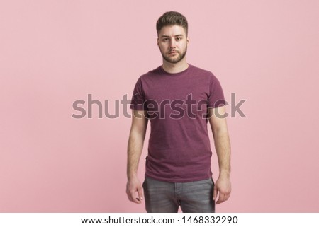 Boy with neutral face on flat color background