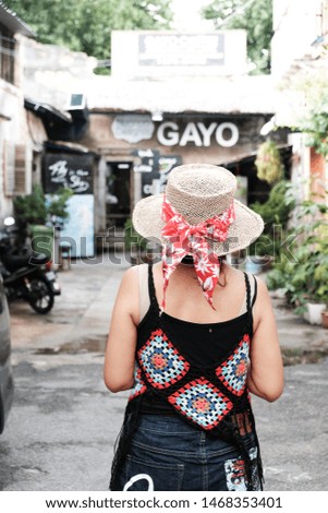 A woman wearing summer hat with red ribbon. People and travel.