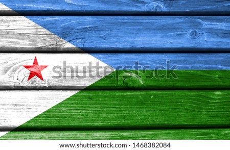 Djibouti flag painted on wooden background, closeup.