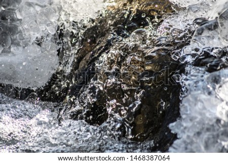 High-speed macro capture of water flowing over icy rocks in winter, River Pcinja, Skopje, Macedonia