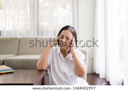 Mature asian elderly women having migraine and headache pain,Senior healthy concept Royalty-Free Stock Photo #1468402997
