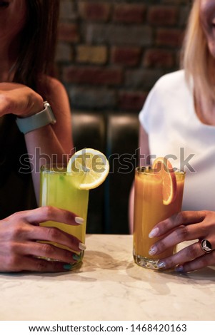 delicious colored cocktail in the hand at girls