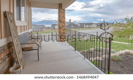 Panorama Porch overlooking yard road homes lake and mountain under cloudy blue sky