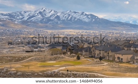 Panorama frame Striking snowy mountain towering over the houses built in the vast valley