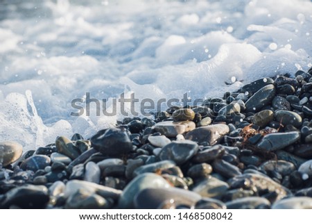 Splash of sea water and foam on the stone shore