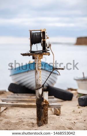 Old rusty boat winches and boats on ramps on a beach close to a fishermen village on the Romanian Black Sea coast