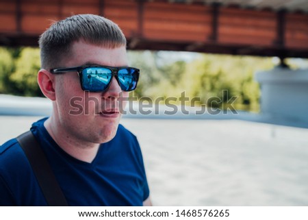 Portrait of young man in casual clothes and with sunglasses.