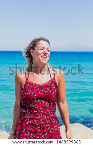 Portrait Photography. A caucasian Blonde woman outdoors in her holidays with an ocean background in her holidays