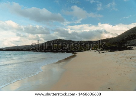 Tropical beach with turquoise ocean waves and white sand. Sand bay view with leading lines. Holiday, vacation, paradise, summer vibes. Shot in Isabela, San Cristobal, Galapagos Islands.