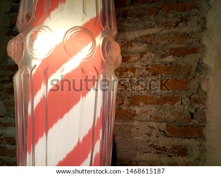 Classic barber pole with brick wall background