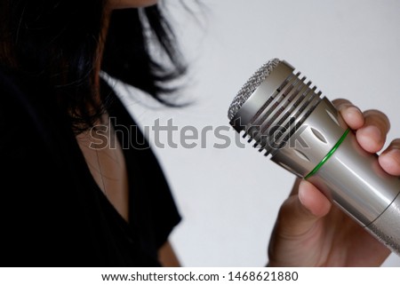 Women hold the microphone in hand.