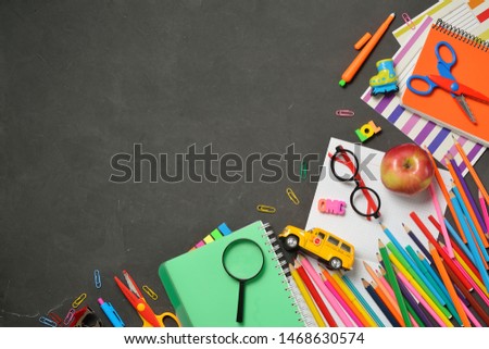 Back to School concept - office and student supplies on black chalk background. Space for text.