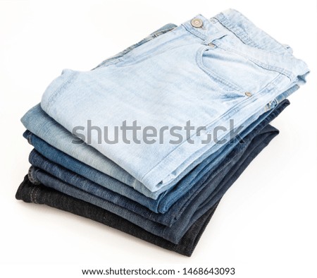 Heap of jeans of various shades. Isolated on white background.