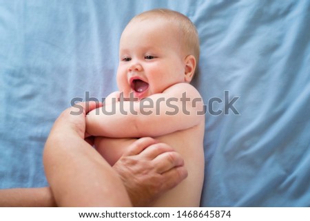 Little smiling toddler enjoys massage.  Baby massage.  Foot massage for baby