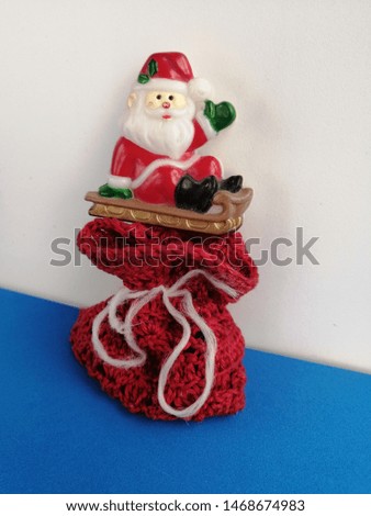 festive merry Santa Claus from above on a red bag with gifts on a blue and white background shot in real natural close-up shot