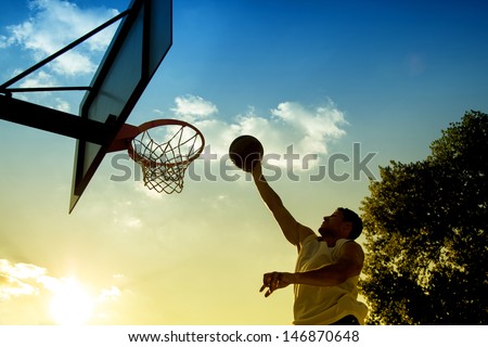 Basketball player silhouette at sunset 