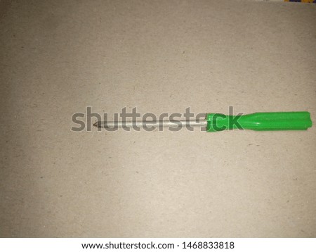 Compare Short Removable one-head screwdriver with green plastic handle isolated on gray  background Royalty-Free Stock Photo #1468833818