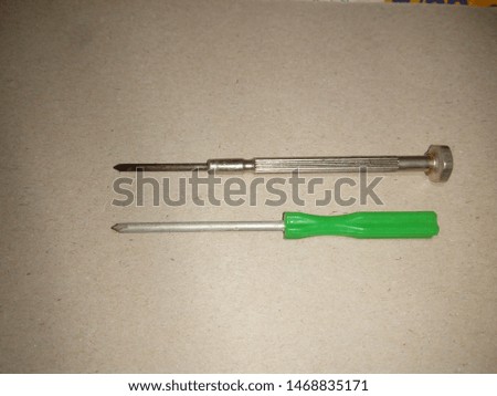 two screwdriver ,head screwdriver with green plastic handle and Precision screwdriver ,on gray background Royalty-Free Stock Photo #1468835171