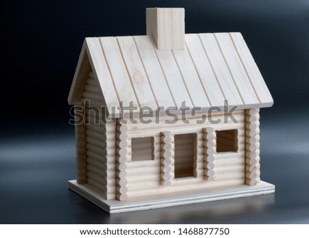 Homemade wooden house on a black background. Chimney, windows and doors.