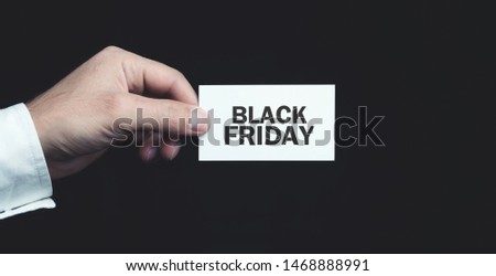 Male hand holding Black Friday text on business card.