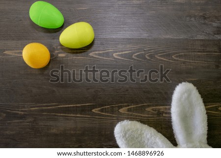 Background with Easter bunny ears and colorful eggs.
