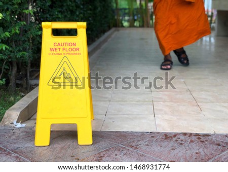 Yellow wet floor caution sign at public toilet.