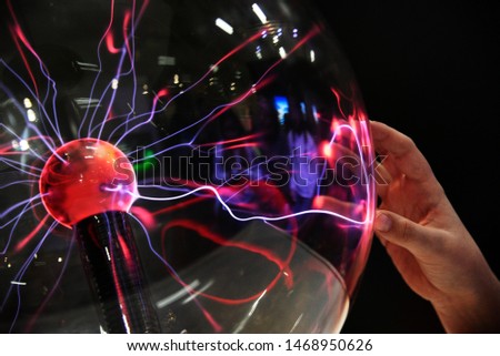 Hand touching with finger electric plasma in glass sphere Royalty-Free Stock Photo #1468950626