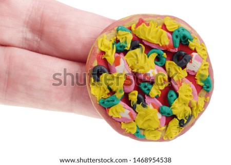 In the future we will eat this concept. Mini pizza made of clay plasticine on fingers. Isolated on white studio macro