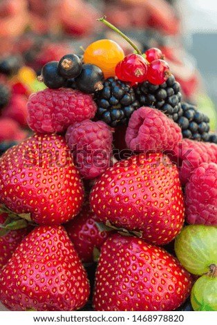 Pile of fresh assorted berries. Vertical close up, can be used as background 