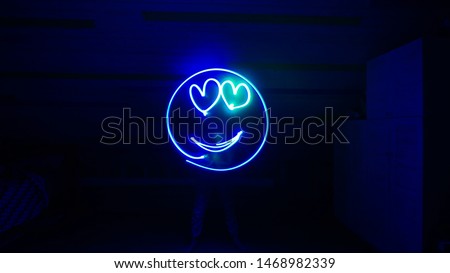 Girl is drawing smile at the dark