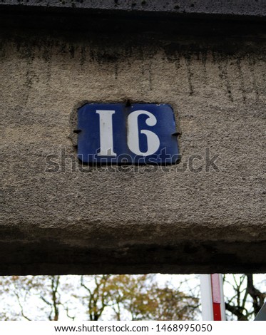 Number 16, street number plate on a facade.