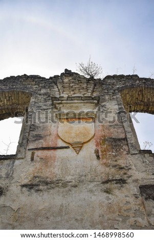 Religious symbol. Ruins of an ancient synagogue with arched windows, against the blue sky. Texture old dilapidated masonry. Tree growing on the wall. Rashkov, Moldova. Selective focus. Copy space.