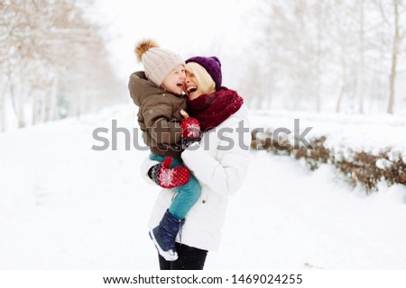 Photo of mother and son, havinf fun, hugging and laughting in a winter walk 