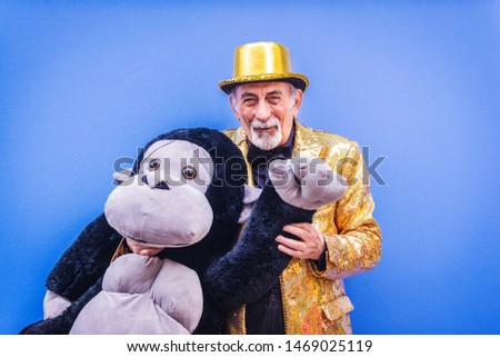 Funny and extravagant senior man posing on colored background - Youthful old man in the sixties having fun and partying Royalty-Free Stock Photo #1469025119