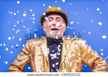 Funny and extravagant senior man posing on colored background - Youthful old man in the sixties having fun and partying Royalty-Free Stock Photo #1469025122
