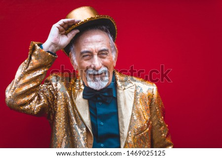 Funny and extravagant senior man posing on colored background - Youthful old man in the sixties having fun and partying Royalty-Free Stock Photo #1469025125