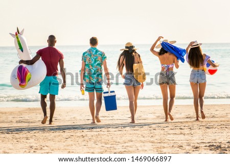 Group of friends having fun on the beach - Young and happy tourists bonding outdoors, enjoying summertime
