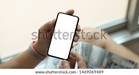 Young man holding blank screen smartphone in the relax day 