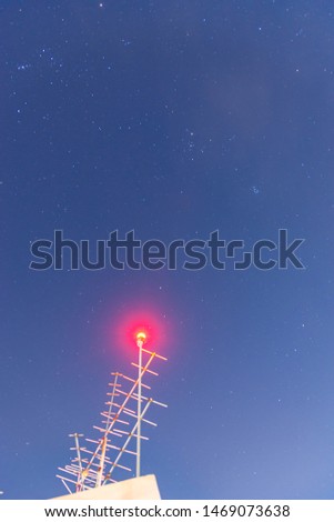 Telecommunications tower and antenna at night with stars in background