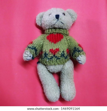 Close-up picture, top view, cute teddy bear  Wearing a winter coat  Separate single, dark pink background
