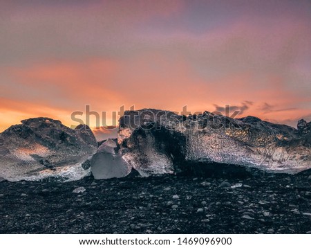 Beautiful cold and colourful landscape picture of icelandic glacier lagoon bay captured in the sunset. Ice on the black volcanic beach near Jokulsarlon glacier lagoon, winter Iceland
