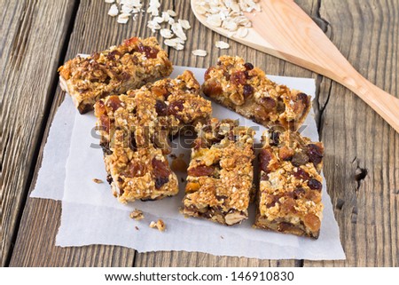 Granola bars with nuts and dried fruits on wooden background
