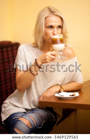 Beautiful girl with white hair is relaxing in a cozy cafe and enjoying aromatic coffee