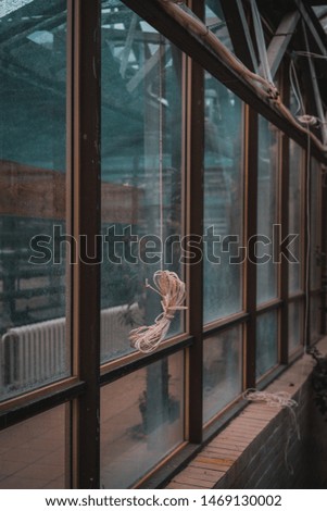 coiled rope hanging behind glass, background, selective focus, film and grain photo