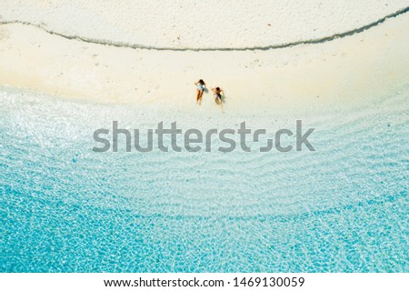 Couple on a tropical beach with blue water and palm trees - Coron, Philippines Royalty-Free Stock Photo #1469130059