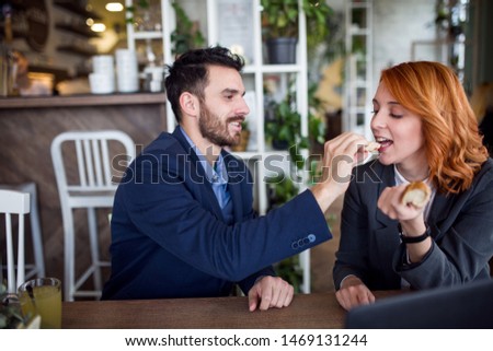 Business couple having fun, eating at restaurant stock photo