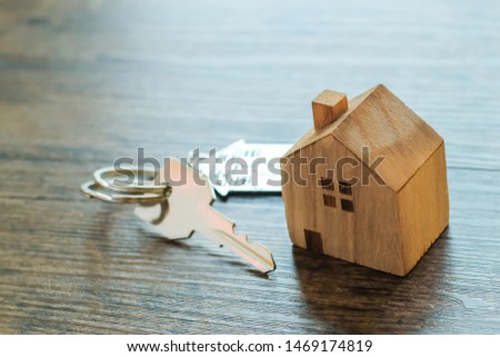 Close up of wood house model and home keys on wooden background.Building, mortgage, real estate and property concept.