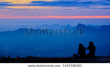 Beautiful sunrise with silhouette traveler at Nok Aen cliff, Phu Kradueng National Park, Loei province, Thailand.